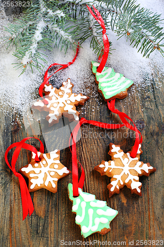 Image of Christmas cookies and spruce branches in the snow.