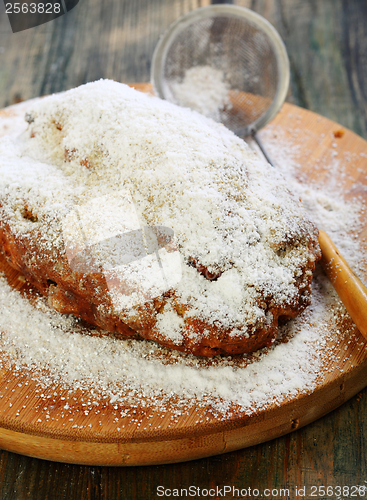 Image of Christmas stollen decorated with powdered sugar.