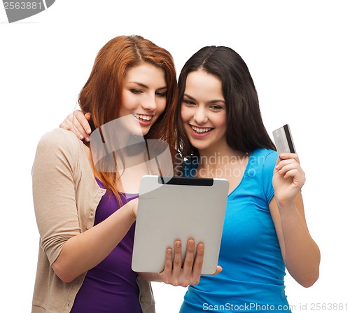Image of two smiling girls with tablet pc and credit card