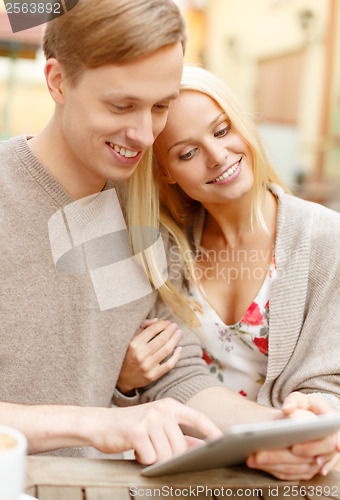 Image of smiling couple with tablet pc computer in cafe