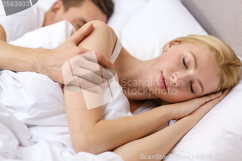 Image of happy couple sleeping in bed