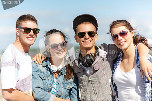 Image of smiling teenagers in sunglasses hanging outside