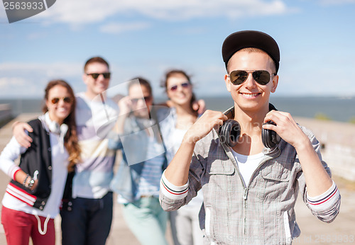 Image of teenage boy with sunglasses and friends outside