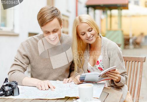 Image of couple with map, camera, city guide and coffee