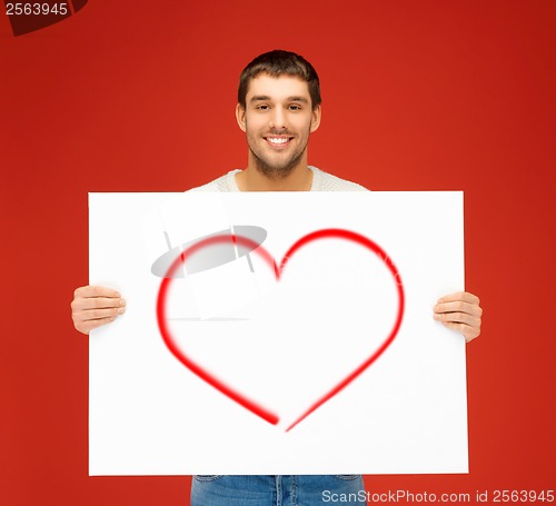 Image of handsome man with big white board and heart on it