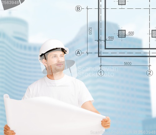 Image of male architect in helmet looking at blueprint