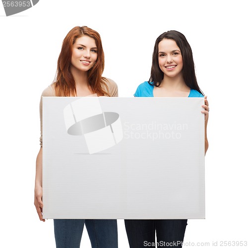 Image of two smiling young girls with blank white board