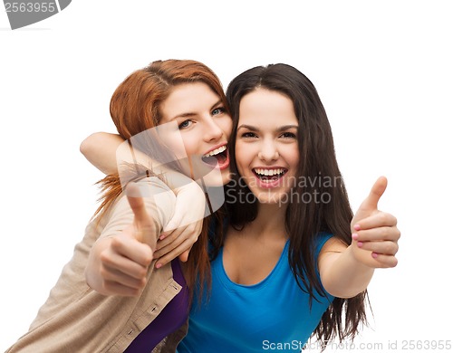 Image of two smiling girls showing thumbs up
