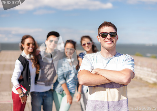 Image of teenage boy with sunglasses and friends outside