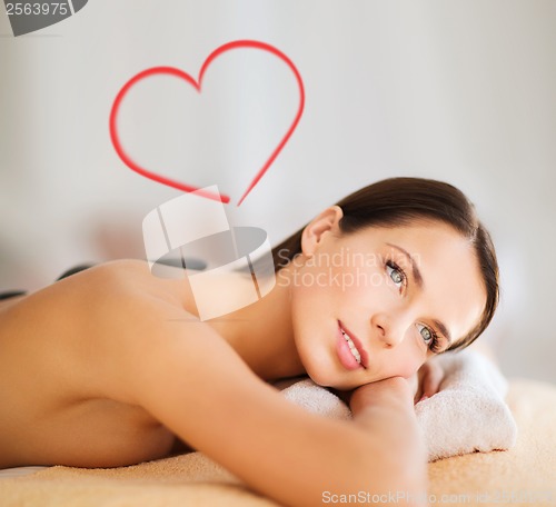 Image of beautiful woman in spa salon with hot stones