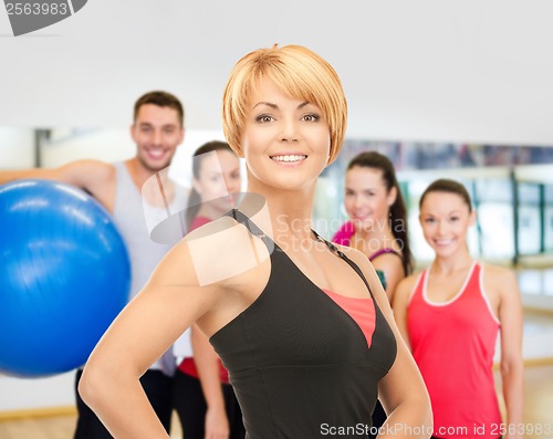 Image of group of smiling people exercising in the gym