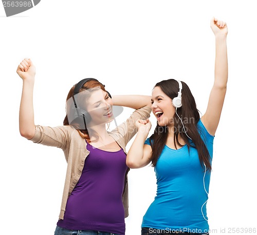 Image of two laughing girls with headphones dancing