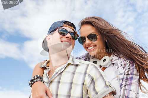 Image of smiling teenagers in sunglasses having fun outside