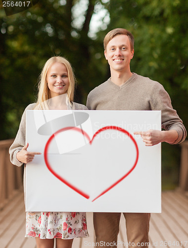 Image of romantic couple with white board and heart on it