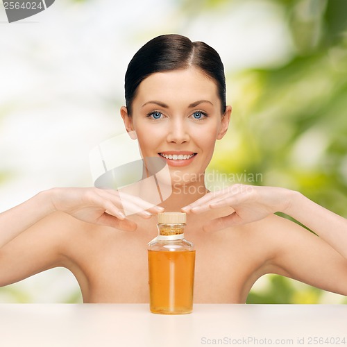 Image of beautiful woman with oil bottle