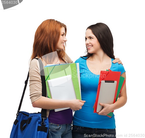 Image of two smiling students with bag and folders