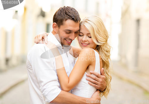 Image of romantic happy couple hugging in the street