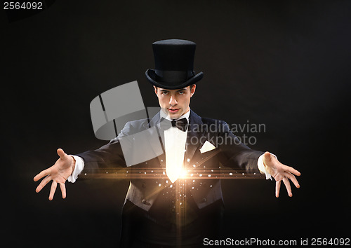 Image of magician in top hat showing trick