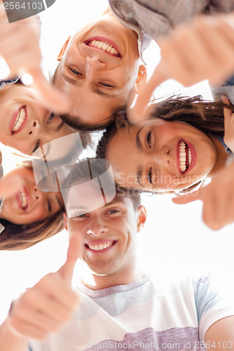 Image of group of smiling teenagers looking down