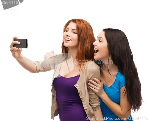 Image of two smiling teenagers with smartphone