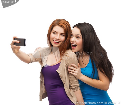 Image of two smiling teenagers with smartphone