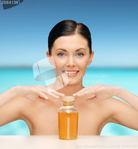 Image of beautiful woman with oil bottle