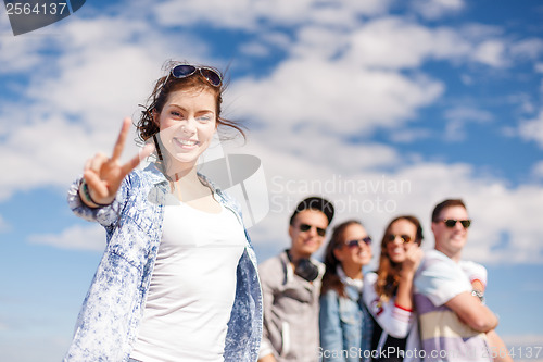 Image of teenage girl with headphones and friends outside