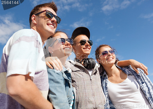 Image of smiling teenagers in sunglasses hanging outside