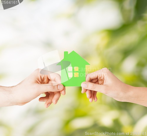 Image of couple hands holding green house