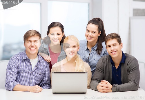 Image of smiling students with laptop at school