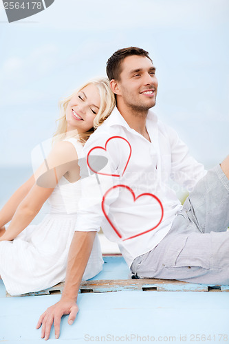 Image of couple sitting on boat at sea side