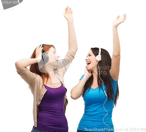 Image of two laughing girls with headphones dancing