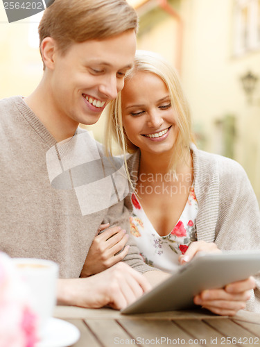 Image of smiling couple with tablet pc computer in cafe