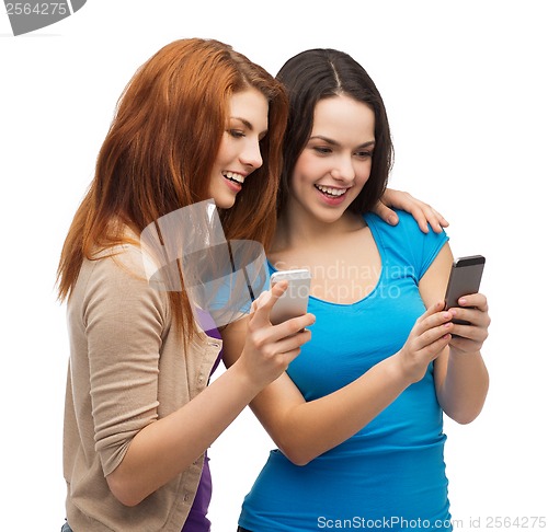 Image of two smiling teenagers with smartphones