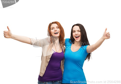 Image of two smiling girls showing thumbs up