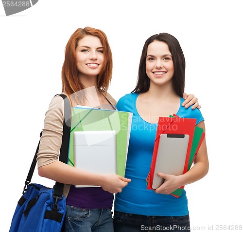 Image of two smiling students with bag, folders and tablet