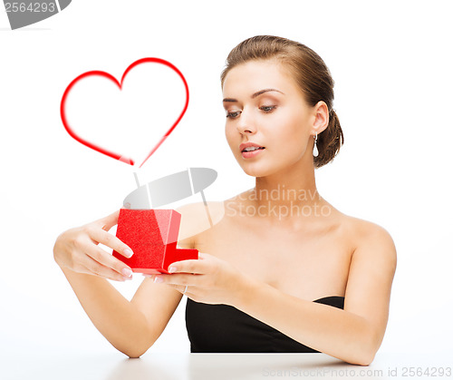 Image of woman with earrings, wedding ring and gift box