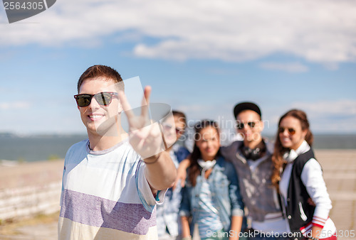 Image of teenage boy with sunglasses and friends outside