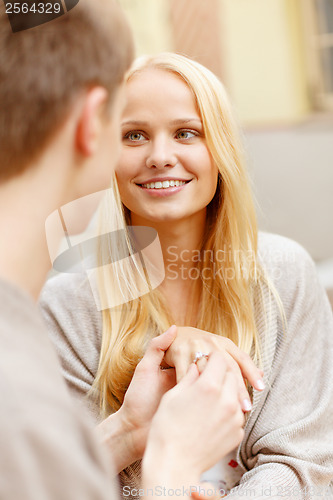 Image of romantic man proposing to beautiful woman