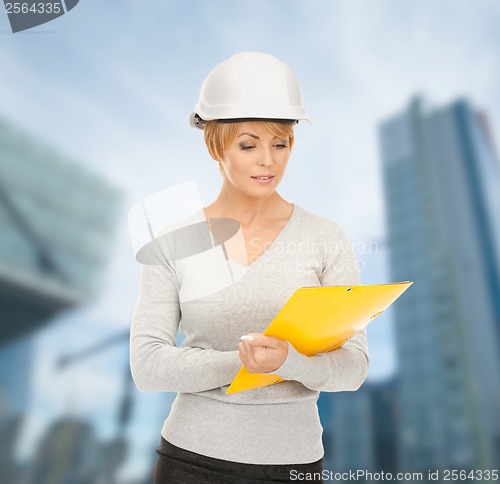 Image of female contractor in helmet with blueprint