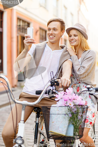 Image of couple with bicycles and smartphone in the city