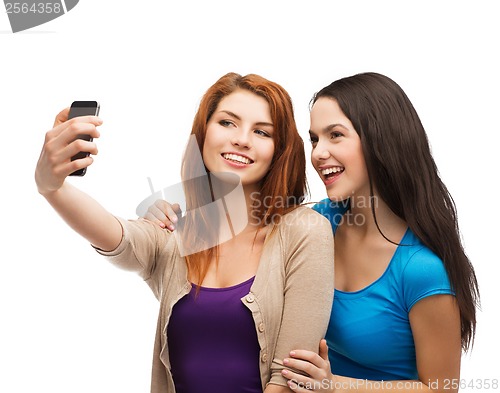 Image of two smiling teenagers with smartphone