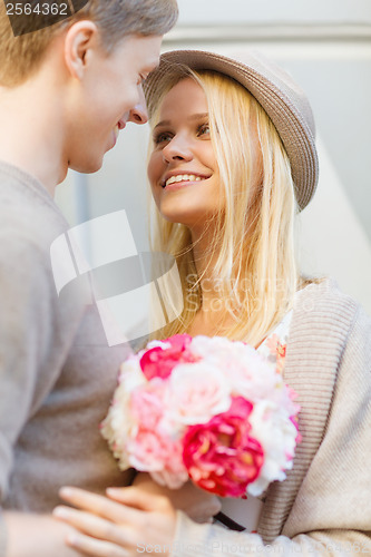 Image of happy couple with flowers in the city