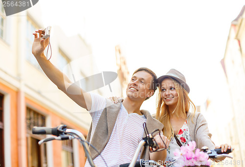 Image of couple with bicycles taking photo with camera