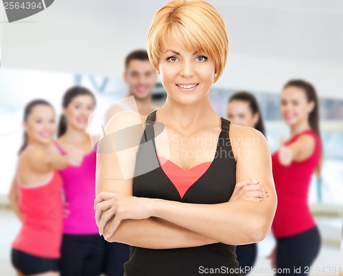 Image of group of smiling people exercising in the gym