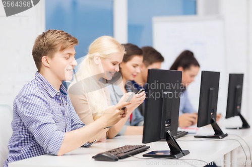Image of students with computer monitor and smartphones