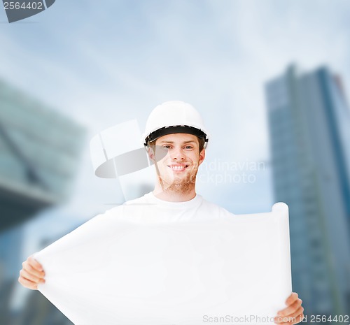 Image of male architect in helmet looking at blueprint