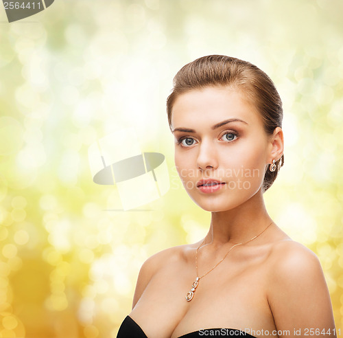 Image of woman wearing shiny diamond earrings and pendant