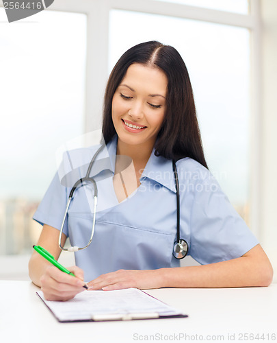 Image of female doctor or nurse writing prescription