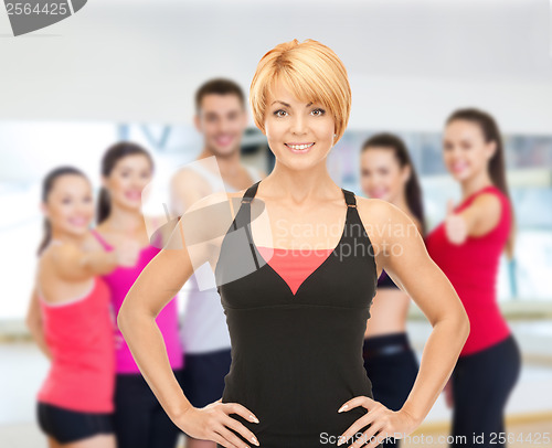 Image of group of smiling people exercising in the gym